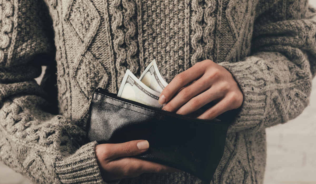 Человек прячет в кошелек среднюю зарплату в Польше - - RU
