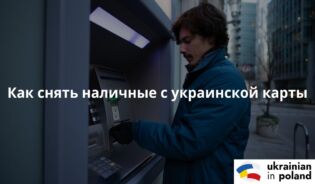 Человек стоит возле банкомата и снимает деньги