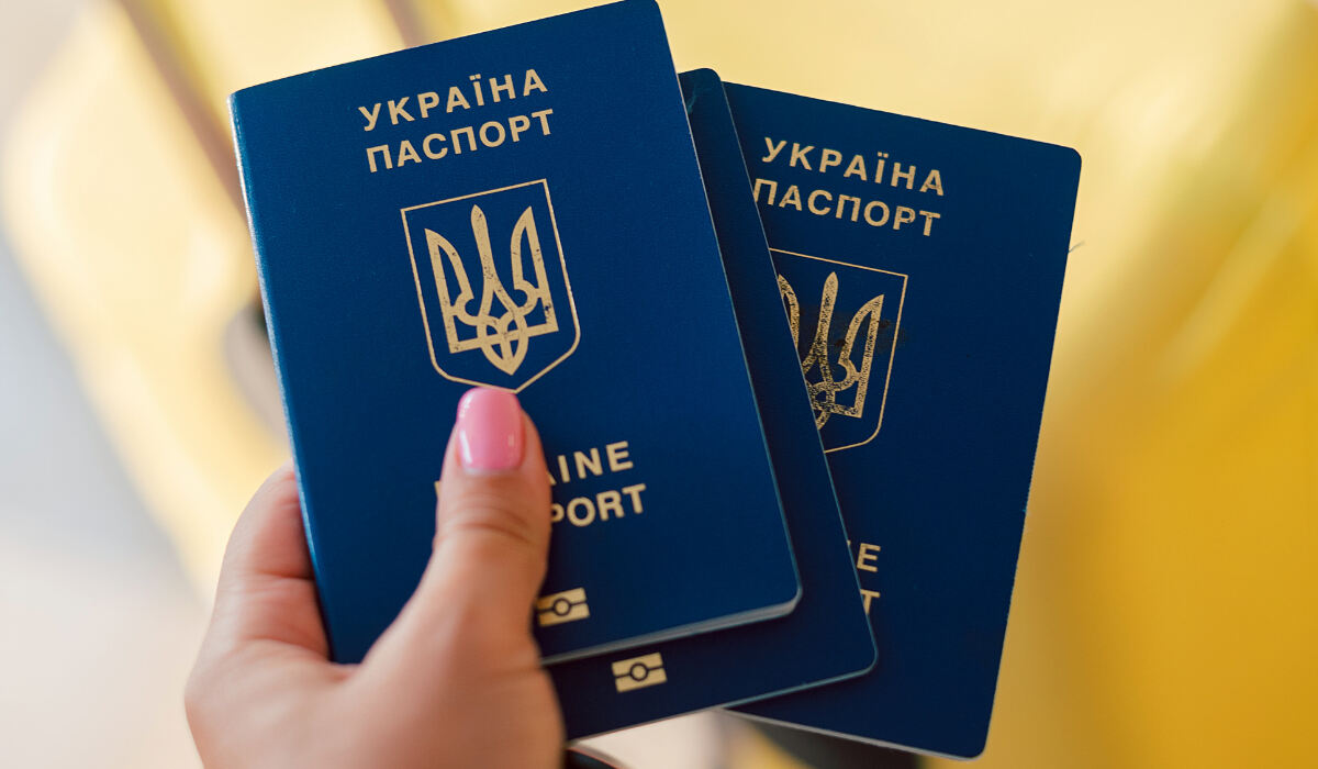 Kobieta trzyma dwa paszporty Ukraińskie wydane w konsulacie