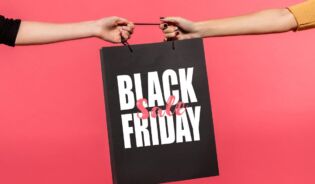 Dwie ręce trzymające czarną torbę na zakupy z napisem Black Friday