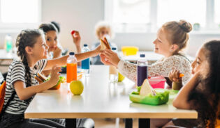 Дети едят еду в школьной столовой. Ru
