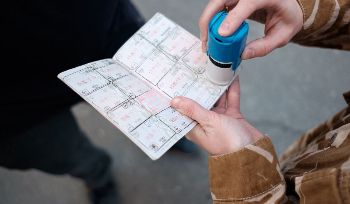 Паспорт у який працівник прикордонної служби Польщі ставить штамп