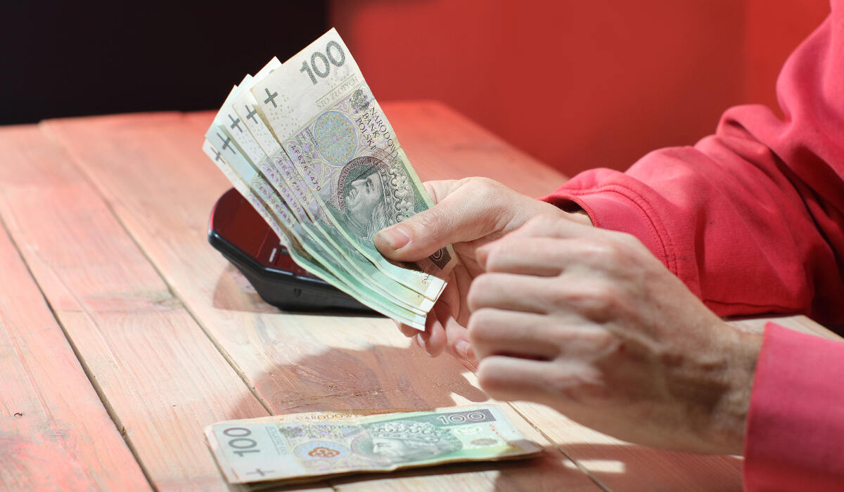 из кармана брюк выглядывает банковская карточка и зарплата в Польше 2023-RU 