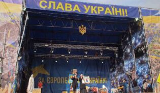 Сцена на евромайдане с плакатом, восхваляющим Украину