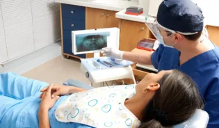 Kobieta, wygodnie rozsiadając się w fotelu dentystycznym, przygotowuje się do wizyty u dentysty.